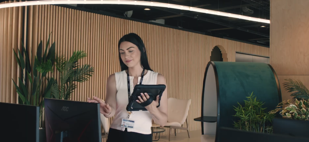 Facility manager reviewing service details using a commercial cleaning checklist in a modern office reception area.